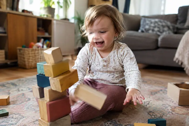Cubes en bois colorés empilés par un jeune enfant