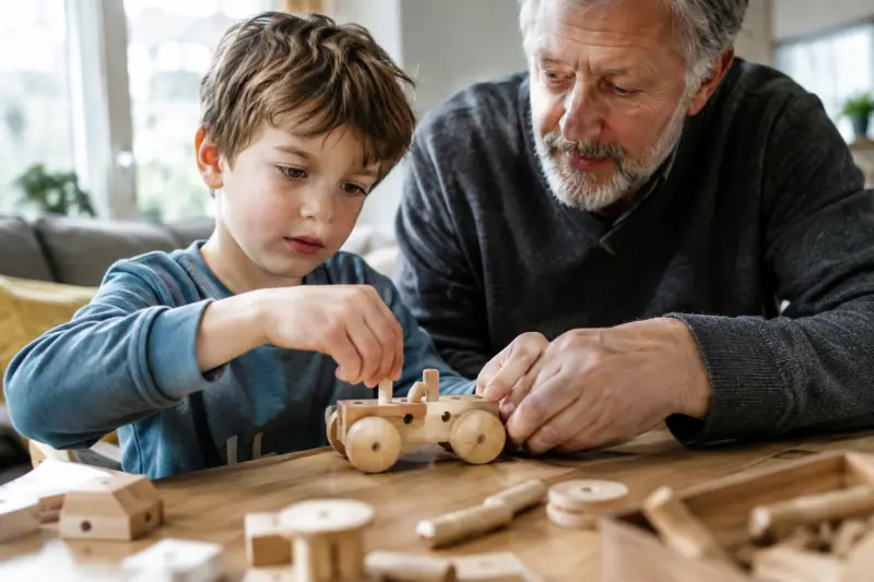 Enfant assemblant une construction en bois avec des cubes et des tiges