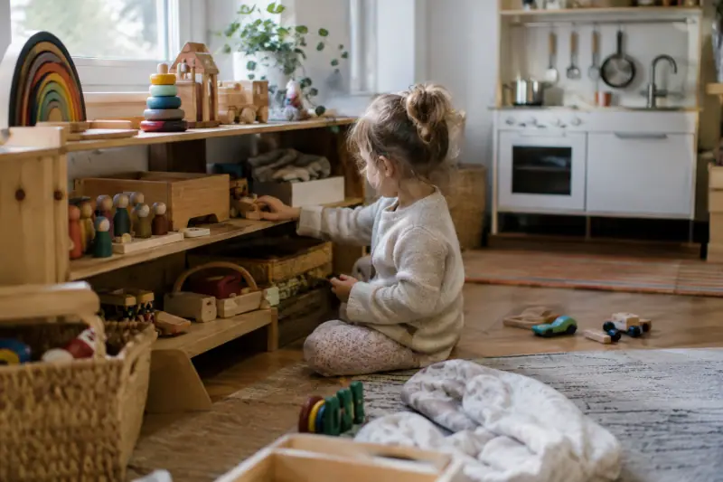 Étagère garnie de jouets en bois variés dans une salle de jeux